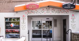 Vista Bahn Ski Rentals shop entrance in Vail, Colorado, featuring colorful signage and decorative floral elements, emphasizing its convenient location next to Gondola One for ski rentals.