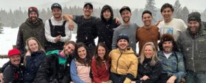 Group of ski rental staff from Vista Bahn Ski Rentals posing together in a snowy outdoor setting, showcasing community and local expertise in Vail, Colorado.